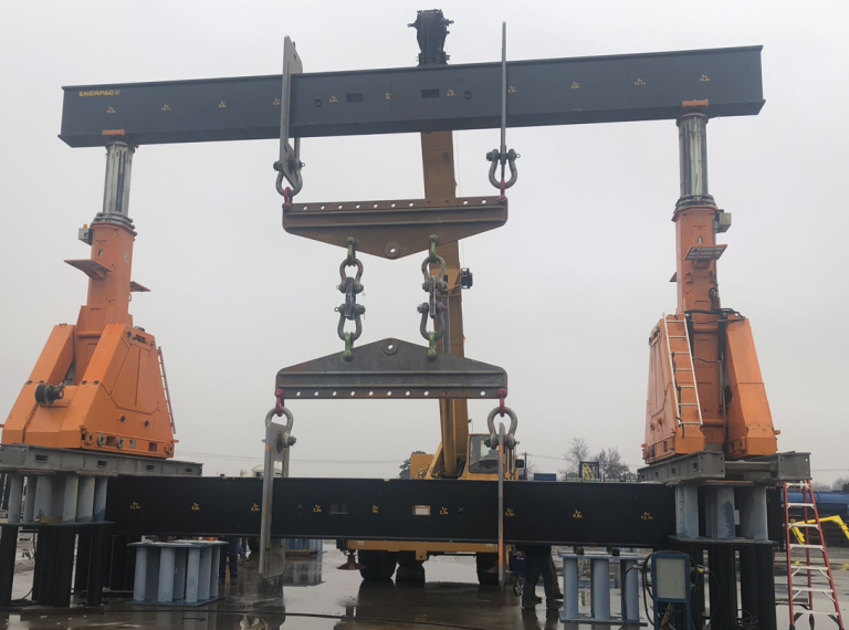 Hydraulic gantries being used to lift heavy equipment.